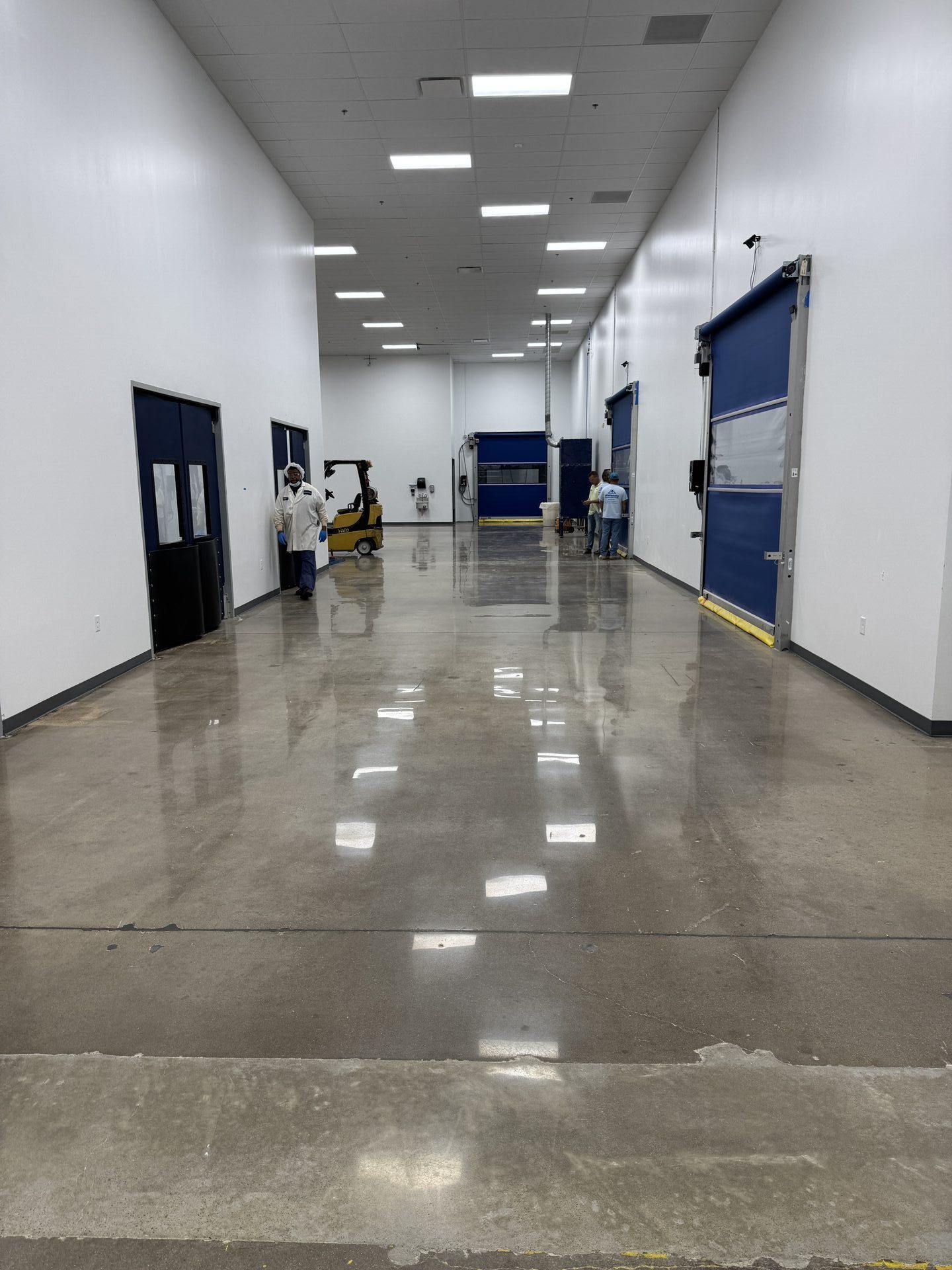 Pharmaceutical plant corridor with finished high-gloss polished concrete reflecting overhead lights
