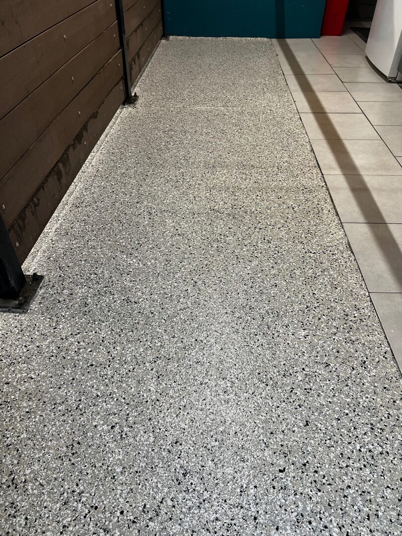 Completed flake floor system in dog kennel area with broadcast polymer flake and polyaspartic topcoat