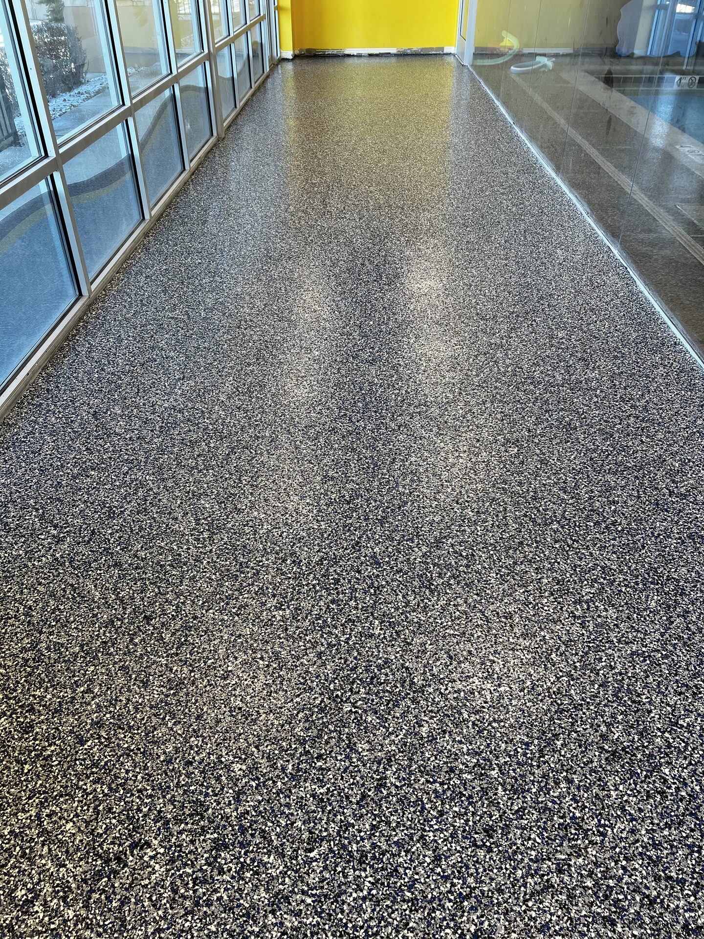 Finished swim school flake floor showing seamless wall-to-wall coverage with no tile seams for water to penetrate