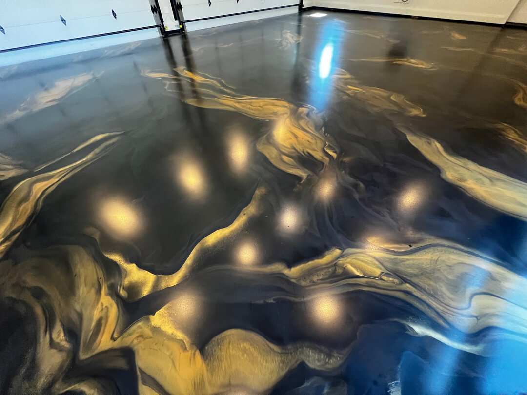 Reinstalled metallic garage floor in luxury Argyle TX home with proper diamond grind, correct epoxy base, and protective topcoat