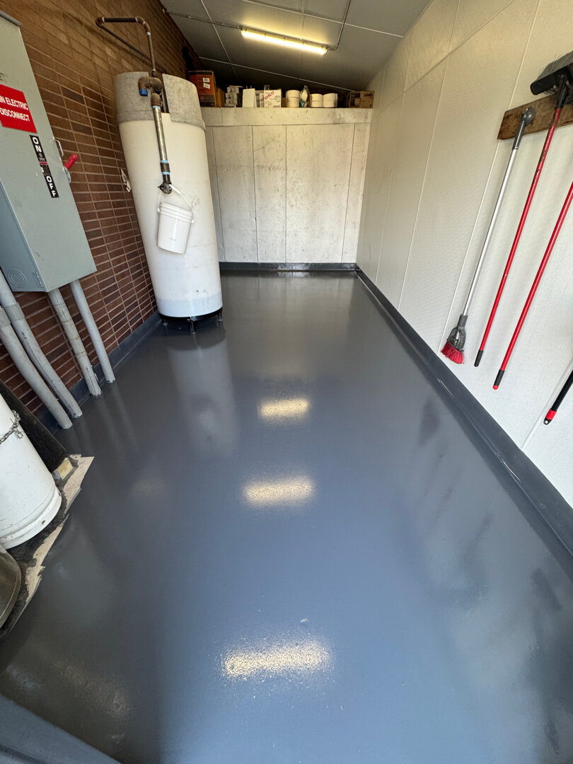 Detail of integrated cove base in restaurant back-of-house — radiused floor-to-wall transition coated in epoxy with no seam