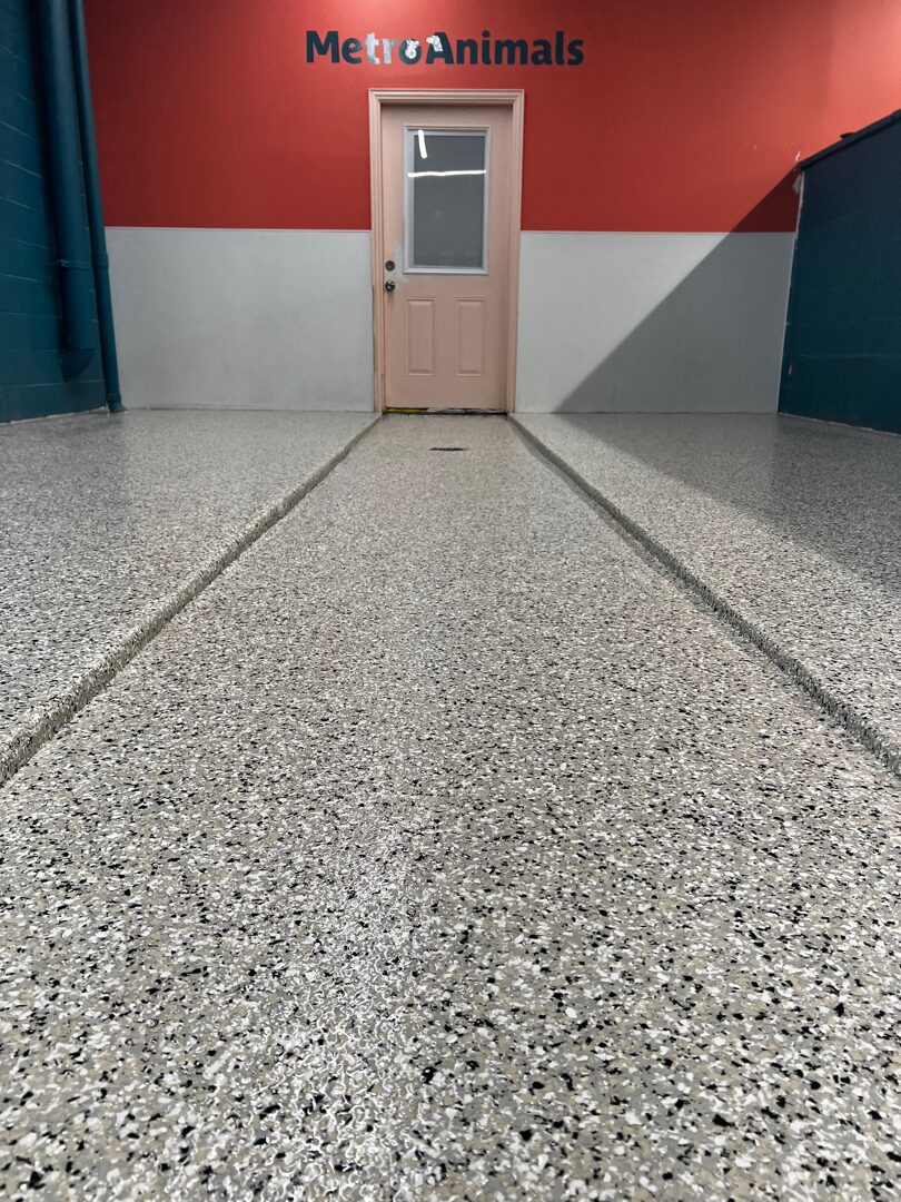 Wide view of completed flake floor in dog training facility — continuous wall-to-wall sanitary surface ready for daily wash-down