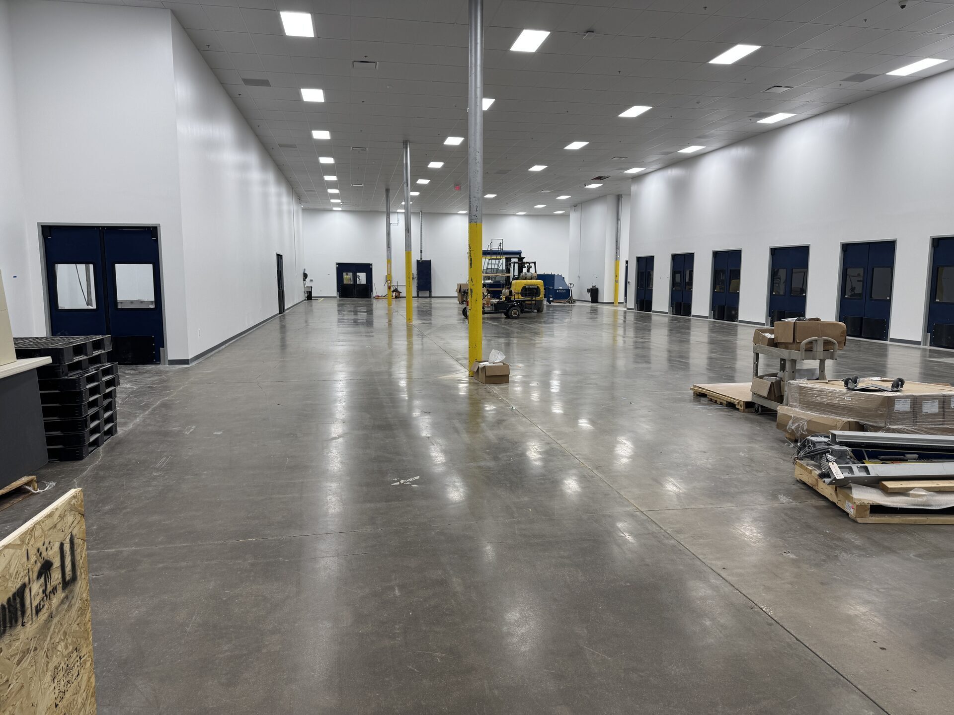 21,000 square foot pharmaceutical manufacturing plant interior in Dallas, TX before polished concrete work — 40-year-old slab with cracking and surface wear