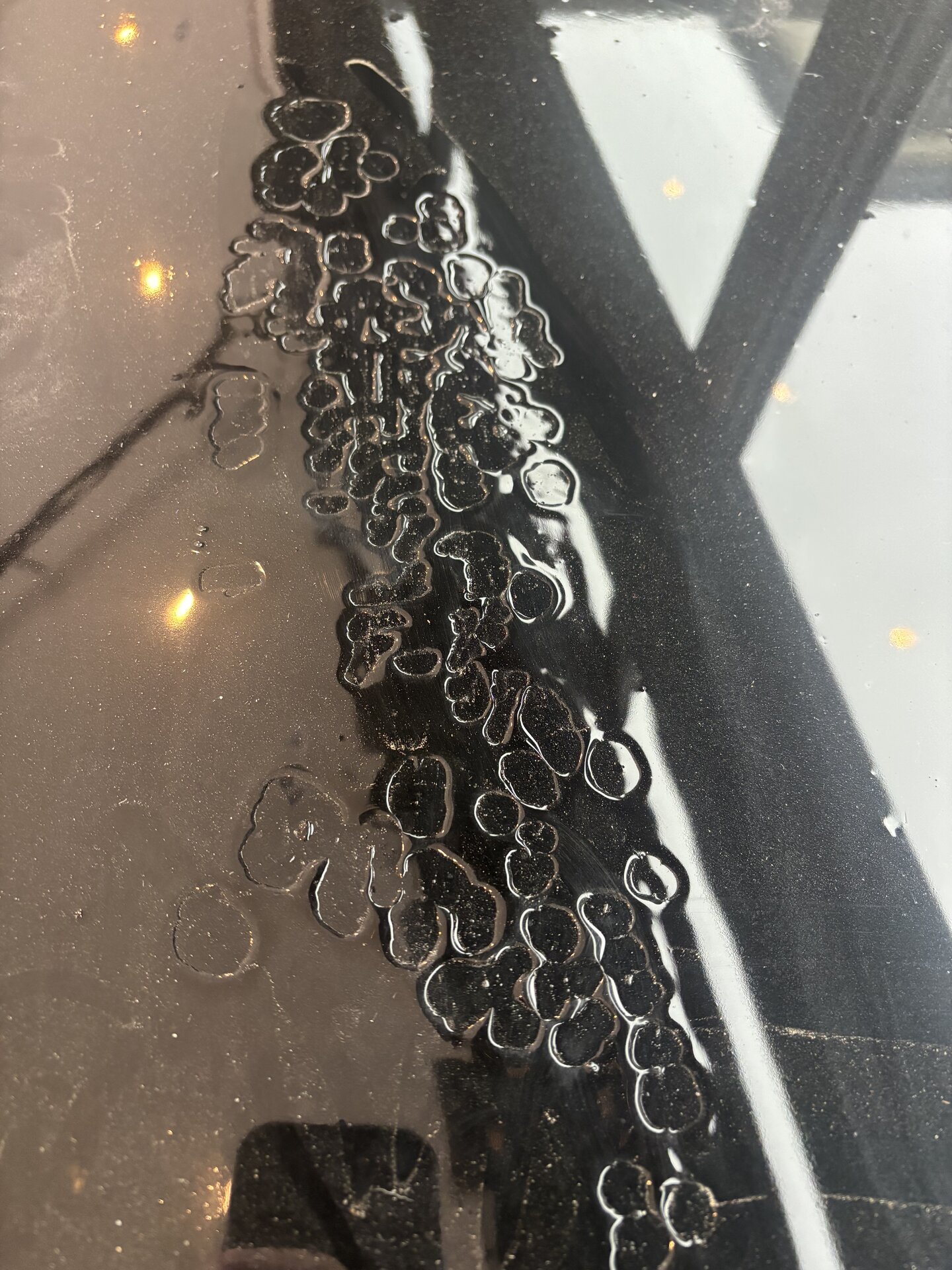 Failed cheap metallic epoxy garage floor in Argyle TX luxury home before Legacy Industrial Coatings tear-out — coating bubbling and peeling off the slab
