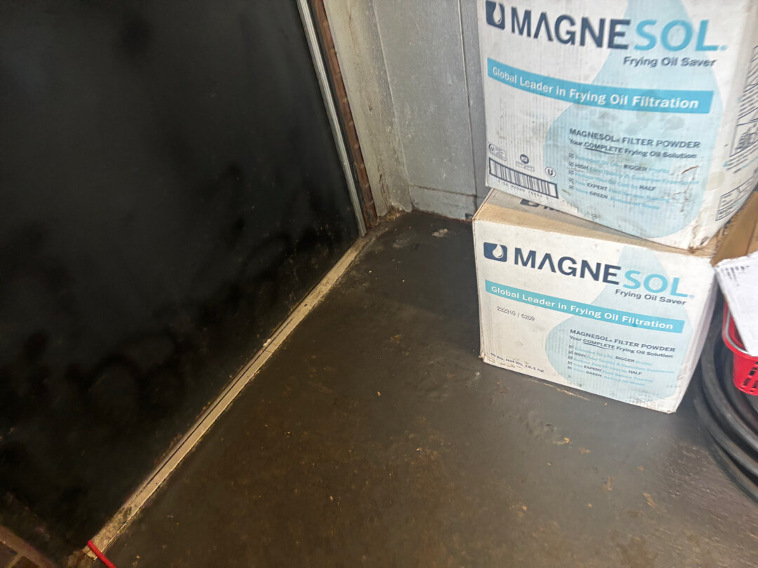 Failed wall-to-floor joint in commercial kitchen pump room flagged on a health inspection before Legacy Industrial Coatings remediation
