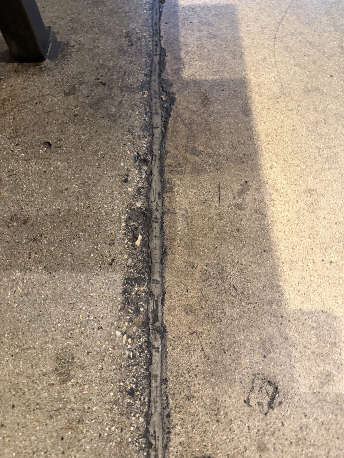 Dull, dusting concrete floor in high-traffic restaurant lane before reseal