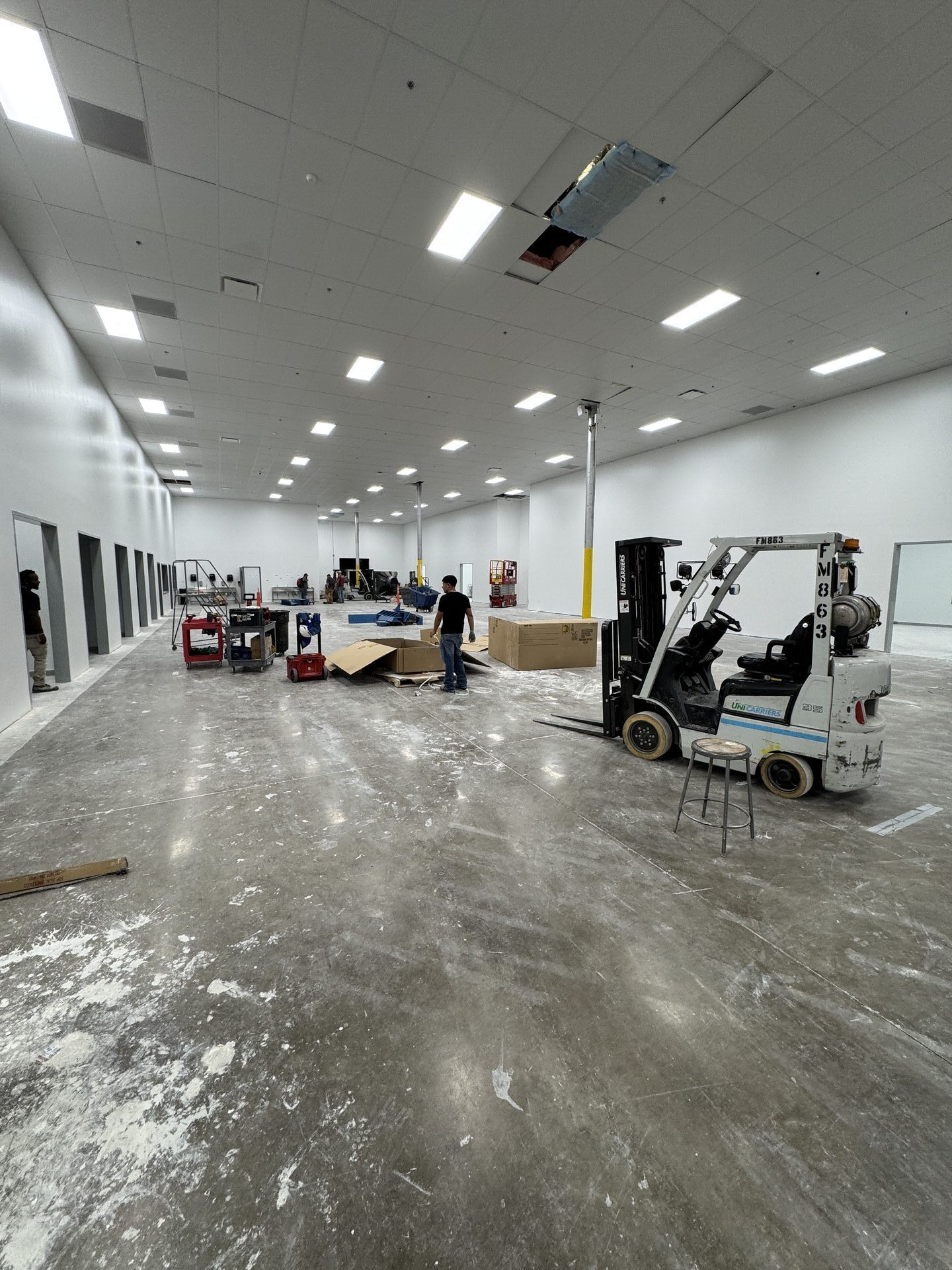 Cracked and worn warehouse-style concrete in pharma plant before mechanical polishing