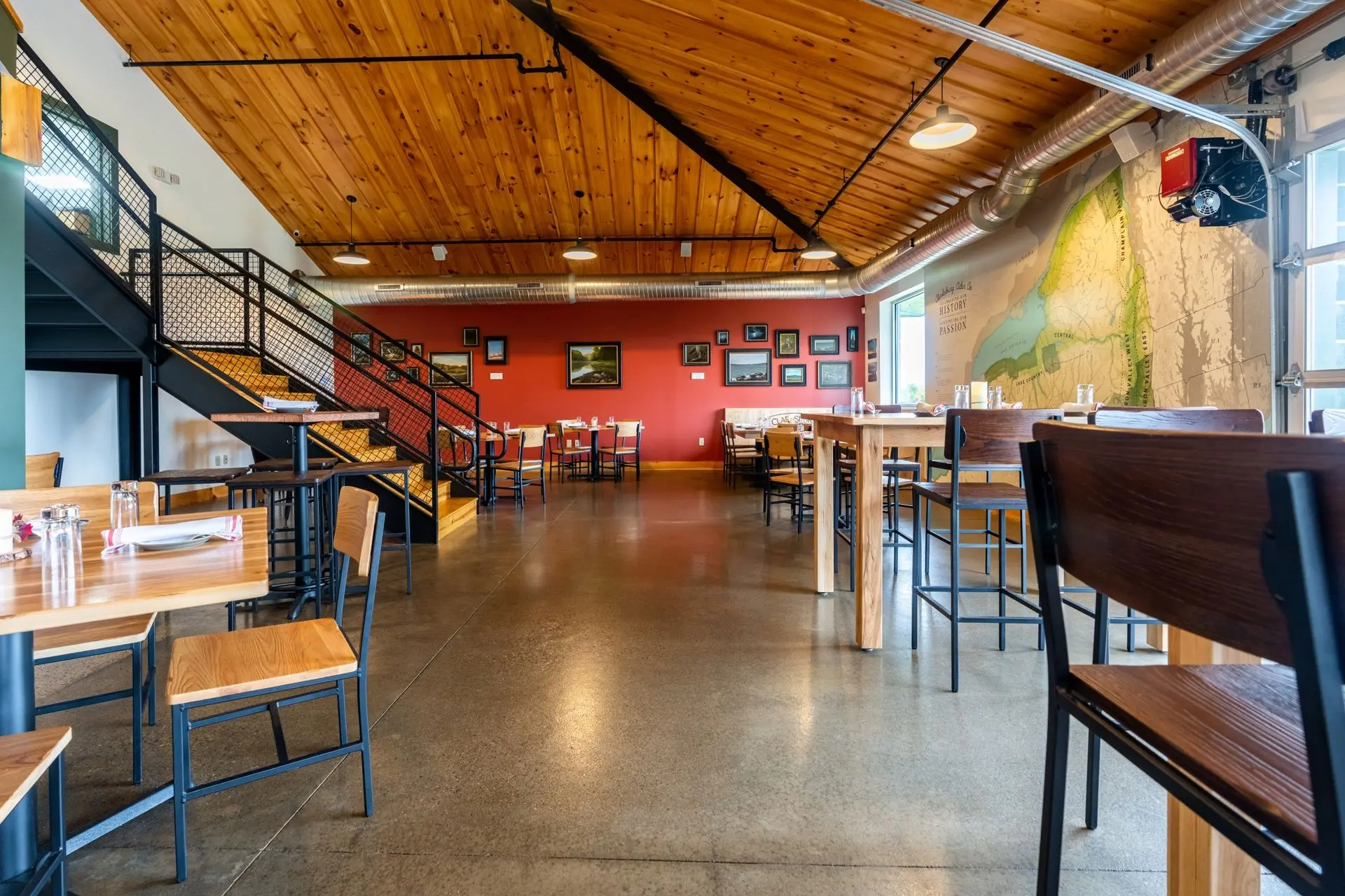 Sealed concrete floor in a cidery tasting room with wood ceiling and dining tables