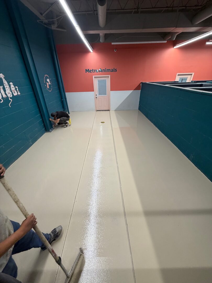 Chipping hammer demolition of old tile underneath failed overlay in dog grooming facility floor
