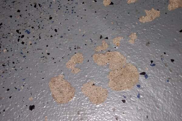 Failed epoxy floor showing chips and peeling