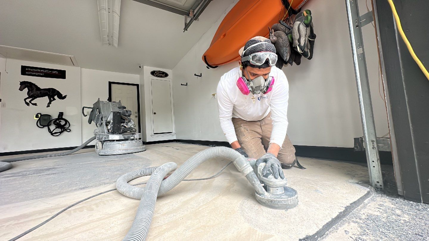 Legacy Industrial Coatings team member preparing garage floor with hand grinder