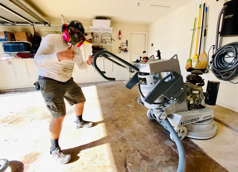 Legacy team member working in residential garage with professional floor coating equipment